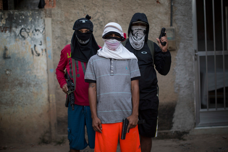“Young drug traffickers pose for a photo wielding their weapons. Teenagers openly tote guns while they work as guards, lookouts and distributors for drug lords operating just a few miles from where hundreds of thousands and tourists and athletes will be for the Aug. 5-21 Olympic Games.”